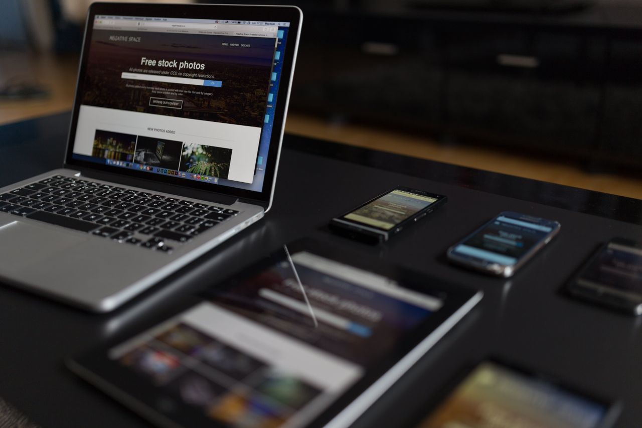 Un espace de travail contemporain mettant en scène un ordinateur portable, une tablette et des smartphones, parfait pour un usage tech et freelance.